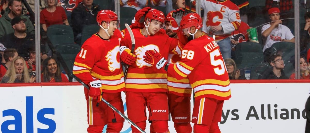 Yegor Sharangovich #17, Rasmus Andersson #4 and teammates of the Calgary Flames celebrate a goal against the Arizona Coyotes at the Scotiabank Saddledome on April 14, 2024 in Calgary, Alberta