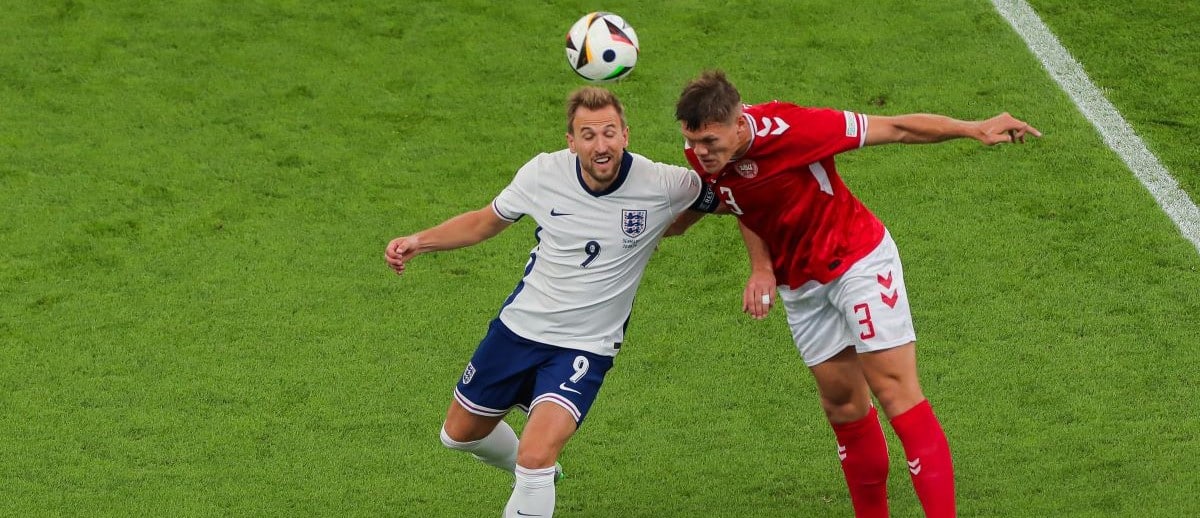 Harry Kane (L) of England jumps to the ball with Jannik Vestergaard (R) of Denmark during the UEFA EURO 2024 group stage match between Denmark and England at Frankfurt Arena on June 20, 2024 in Frankfurt am Main, Germany.