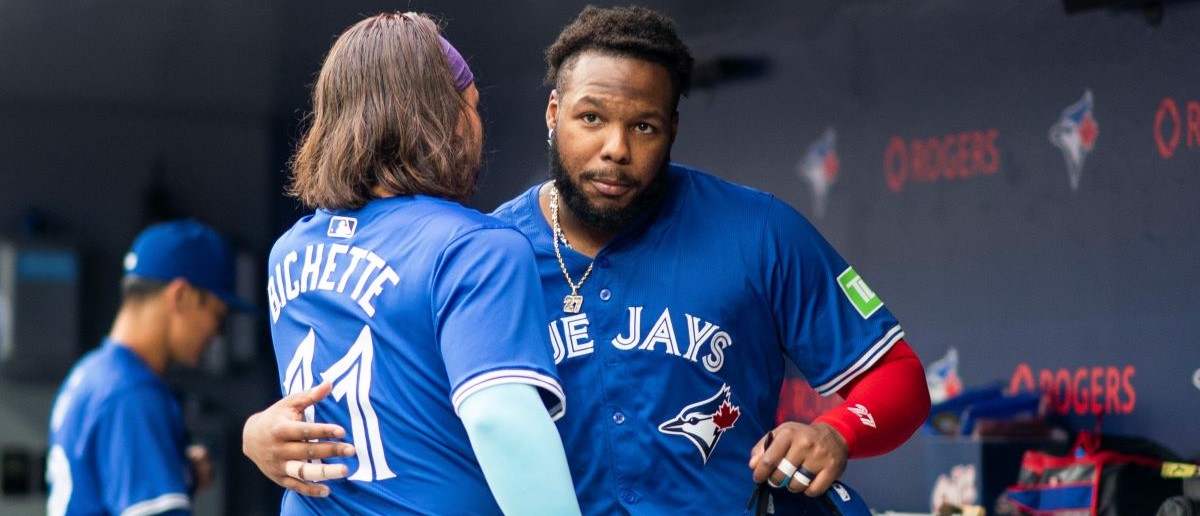 Vladimir Guerrero Jr. #27 and Bo Bichette #11 of the Toronto Blue Jays hug in the dugout before playing the Houston Astros in their MLB game at the Rogers Centre on July 2, 2024 in Toronto, Ontario, Canada