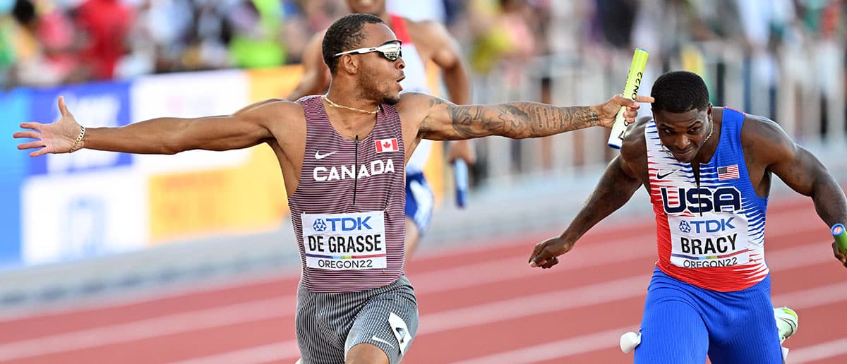 Gold medalist Andre de Grasse (L) of Team Canada crosses the finish line ahead of Marvin Bracy (R) of Team United States in the Men's 4x100m Relay Final during the eighteenth edition of the World Athletics Championships at Hayward Field in Eugene, Oregon, United States on July 23, 2022