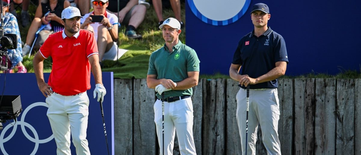 Scottie Scheffler of Team USA, Rory McIlroy of Team Ireland and Ludvig Åberg of Team Sweden stand as they are introduced on the first tee during the first round of the Olympic men's golf competition on day six of the Olympic Games Paris 2024 at Le Golf National on August 1, 2024 in Saint-Quentin-en-Yvelines, France