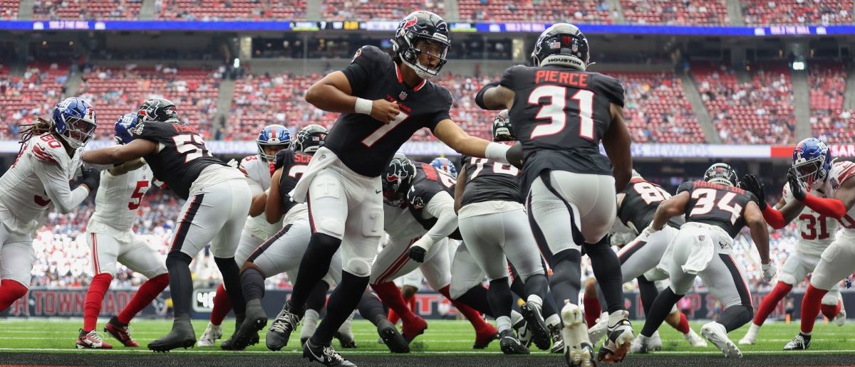 C.J. Stroud #7 of the Houston Texans hands off to Dameon Pierce #31 in the first quarter against the New York Giants during the preseason game at NRG Stadium on August 17, 2024 in Houston, Texas.