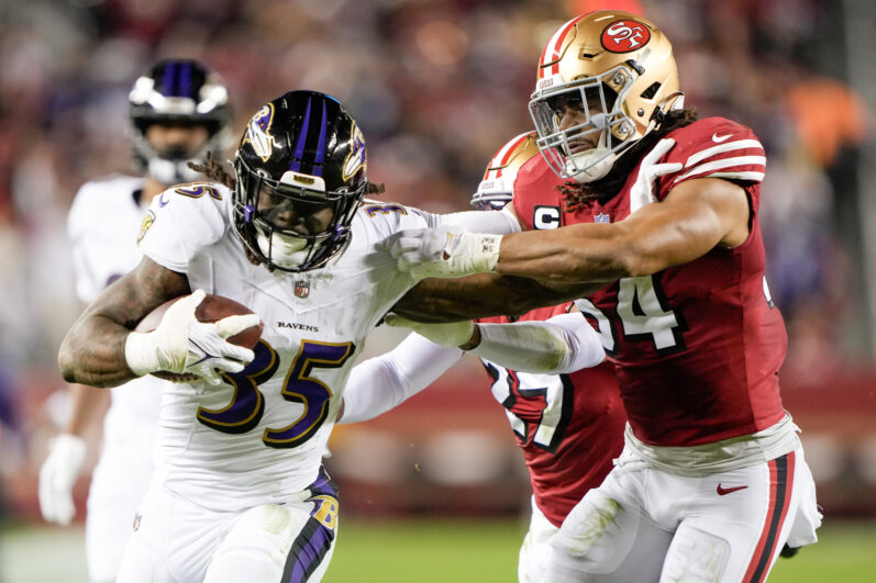 SANTA CLARA, CALIFORNIA - DECEMBER 25: Gus Edwards #35 of the Baltimore Ravens stiff arms Fred Warner #54 of the San Francisco 49ers during the third quarter at Levi's Stadium on December 25, 2023 in Santa Clara, California. (Photo by Thearon W. Henderson/Getty Images)