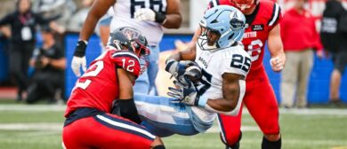 Montreal Alouettes defensive back Najee Murray (12) tackles Toronto Argonauts running back Ka'Deem Carey (25) during the Toronto Argonauts versus the Montreal Alouettes game on July 11, 2024, at Percival Molson Memorial Stadium in Montreal, QC