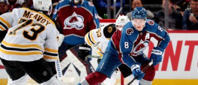 Cale Makar #8 of the Colorado Avalanche skates against Charlie McAvoy #73 of the Boston Bruins at Ball Arena on December 7, 2022 in Denver, Colorado.