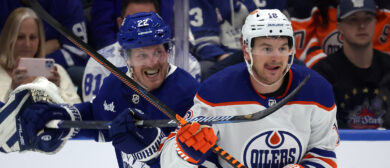 Toronto Maple Leafs defenseman Jake McCabe (22) battles with Edmonton Oilers left wing Zach Hyman (18) as the Toronto Maple Leafs play the Edmonton Oilers at Scotiabank Arena in Toronto. March 23, 2024.