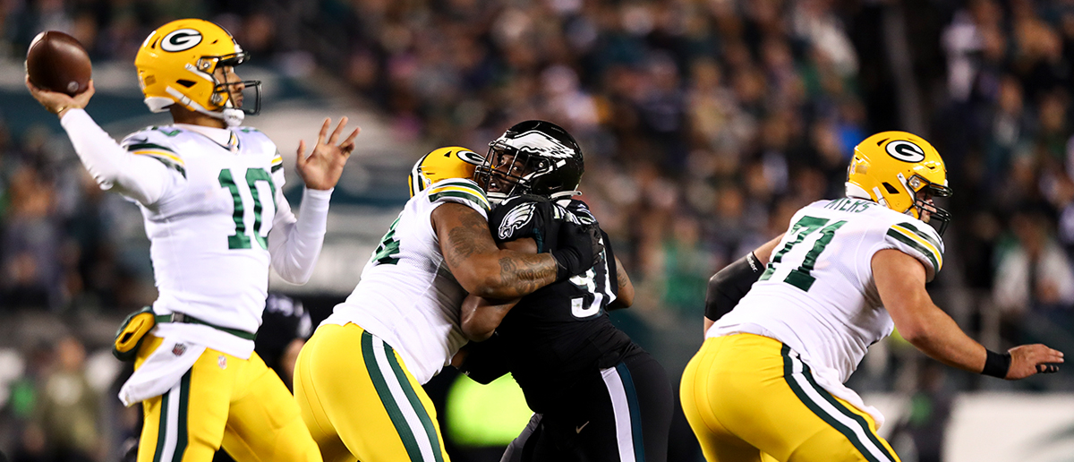 Elgton Jenkins #74 of the Green Bay Packers blocks Javon Hargrave #97 of the Philadelphia Eagles during an NFL football game at Lincoln Financial Field on November 27, 2022 in Philadelphia, Pennsylvania.