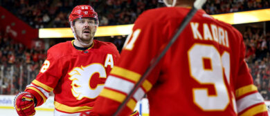 MacKenzie Weegar #52 of the Calgary Flames celebrates a third-period goal by Nazem Kadri #91 against the Arizona Coyotes during their game at the Scotiabank Saddledome on April 14, 2024, in Calgary, Alberta, Canada.