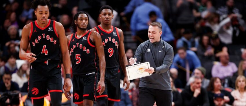 Darko Rajakovic, head coach of the Toronto Raptors, talks with Scottie Barnes #4, Immanuel Quickley #5, and RJ Barrett #9 during the second half of their NBA game against the Boston Celtics at Scotiabank Arena on January 15, 2024 in Toronto, Canada