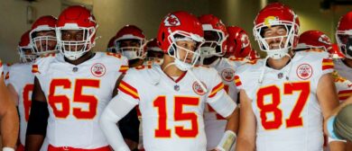 Kansas City Chiefs tight end Travis Kelce (87), right, grins next to Kansas City Chiefs quarterback Patrick Mahomes (15) and Kansas City Chiefs guard Trey Smith (65) before they run onto the field to face the Chargers at the So-Fi Stadium on September 29, 2024 in Inglewood, California.