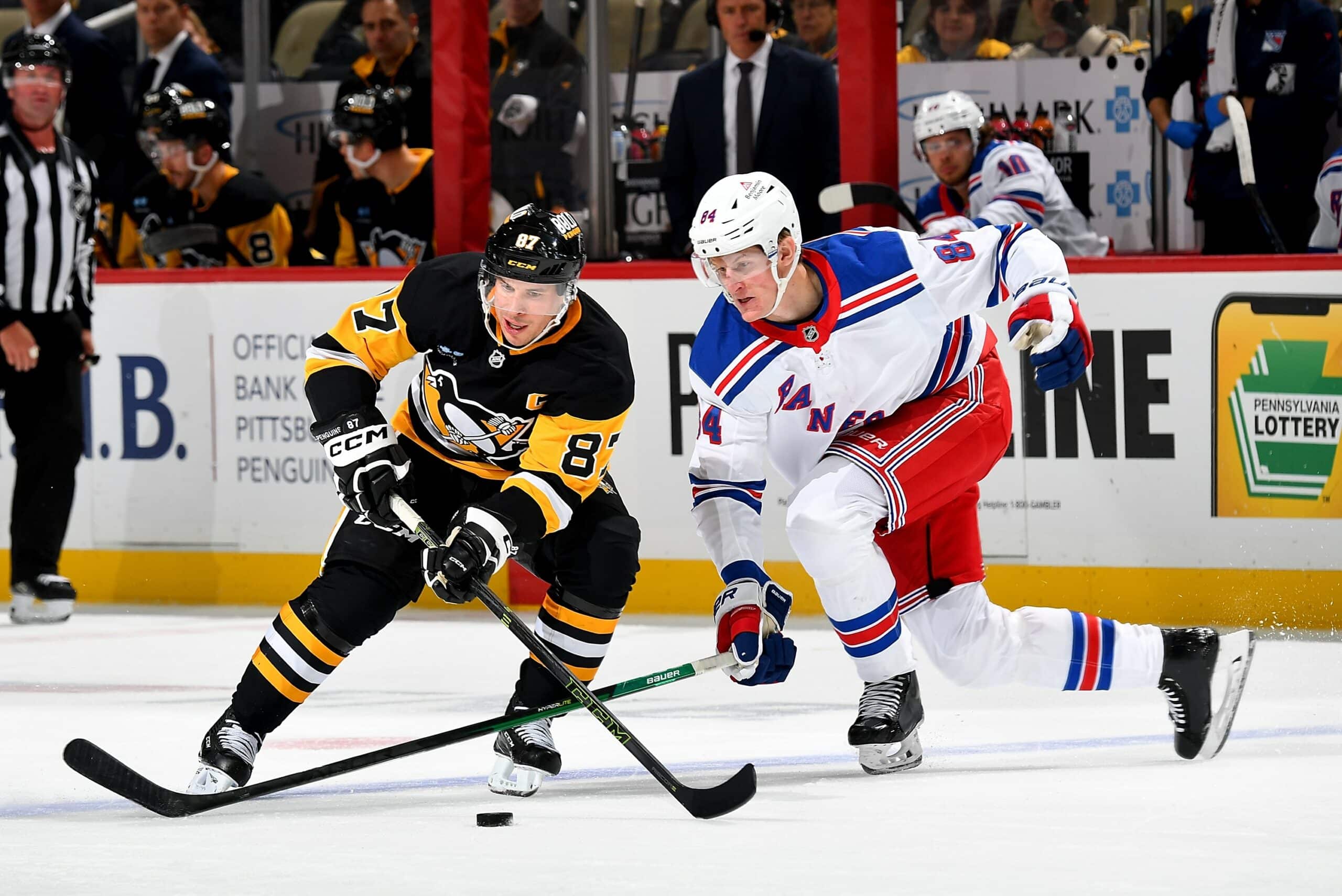 Sidney Crosby of the Pittsburgh Penguins battles against Adam Edstrom of the New York Rangers at PPG PAINTS Arena on October 9, 2024 in Pittsburgh, Pennsylvania.