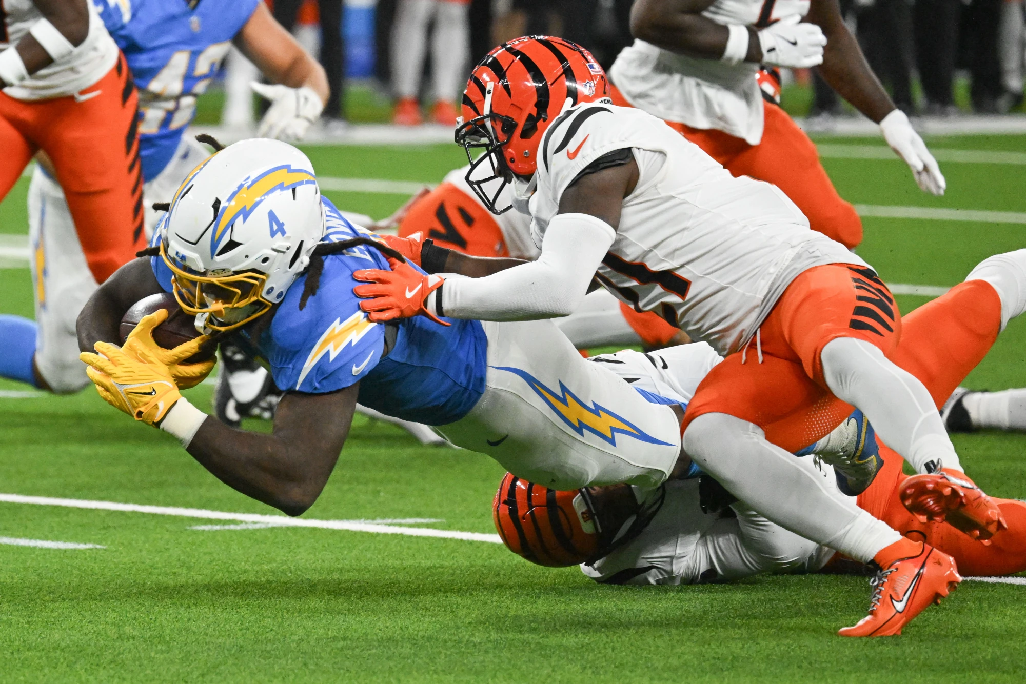 Chargers Gus Edwards dives for yardage as Bengals Mike Hilton makes the tackle during week 11 NFL action at SoFi Stadium on Sunday, November 17, 2024.