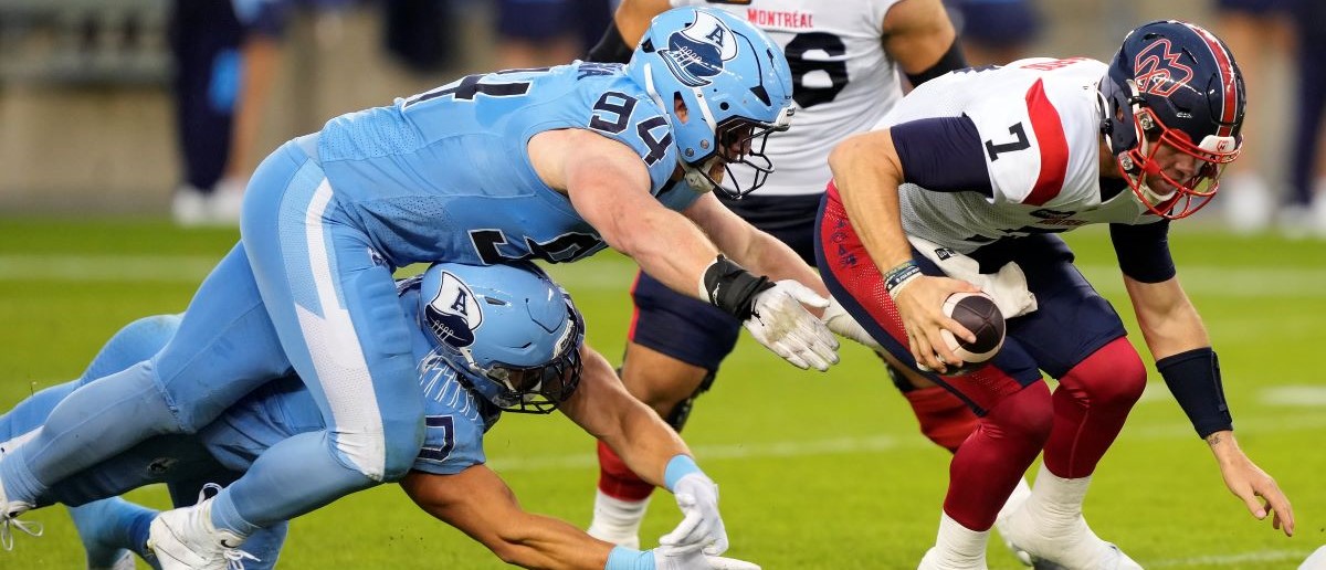 Jake Ceresna #94 and Thiadric Hansen #90 of the Toronto Argonauts force Cody Fajardo #7 of the Montreal Alouettes out of the pocket at BMO Field on June 28, 2024 in Toronto, Canada.