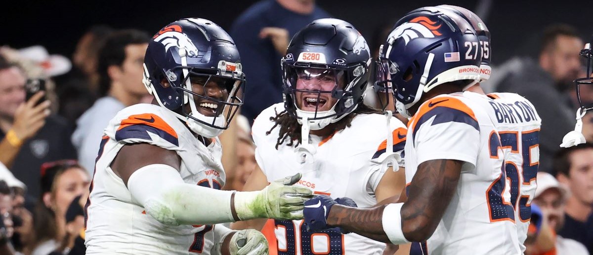 Malcolm Roach #97, Levelle Bailey #56, and Damarri Mathis #27 of the Denver Broncos celebrate after Roach's fumble recovery in the fourth quarter of a game against the Las Vegas Raiders at Allegiant Stadium on November 24, 2024 in Las Vegas, Nevada.