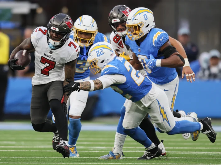 ampa Bay Buccaneers running back Bucky Irving (7) runs past Chargers defenders at SoFi Stadium in Inglewood, CA, on Sunday, December 15, 2024.