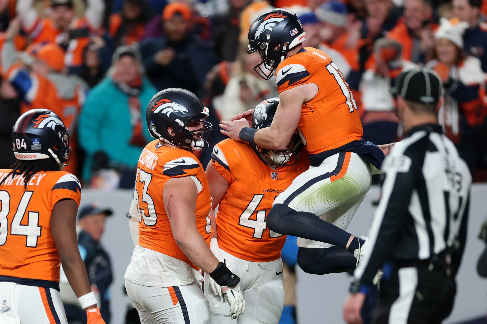 Nate Adkins #45 of the Denver Broncos celebrates with teammate Bo Nix #10 after scoring a touchdown against the Indianapolis Colts during the fourth quarter at Empower Field At Mile High on December 15, 2024 in Denver, Colorado.