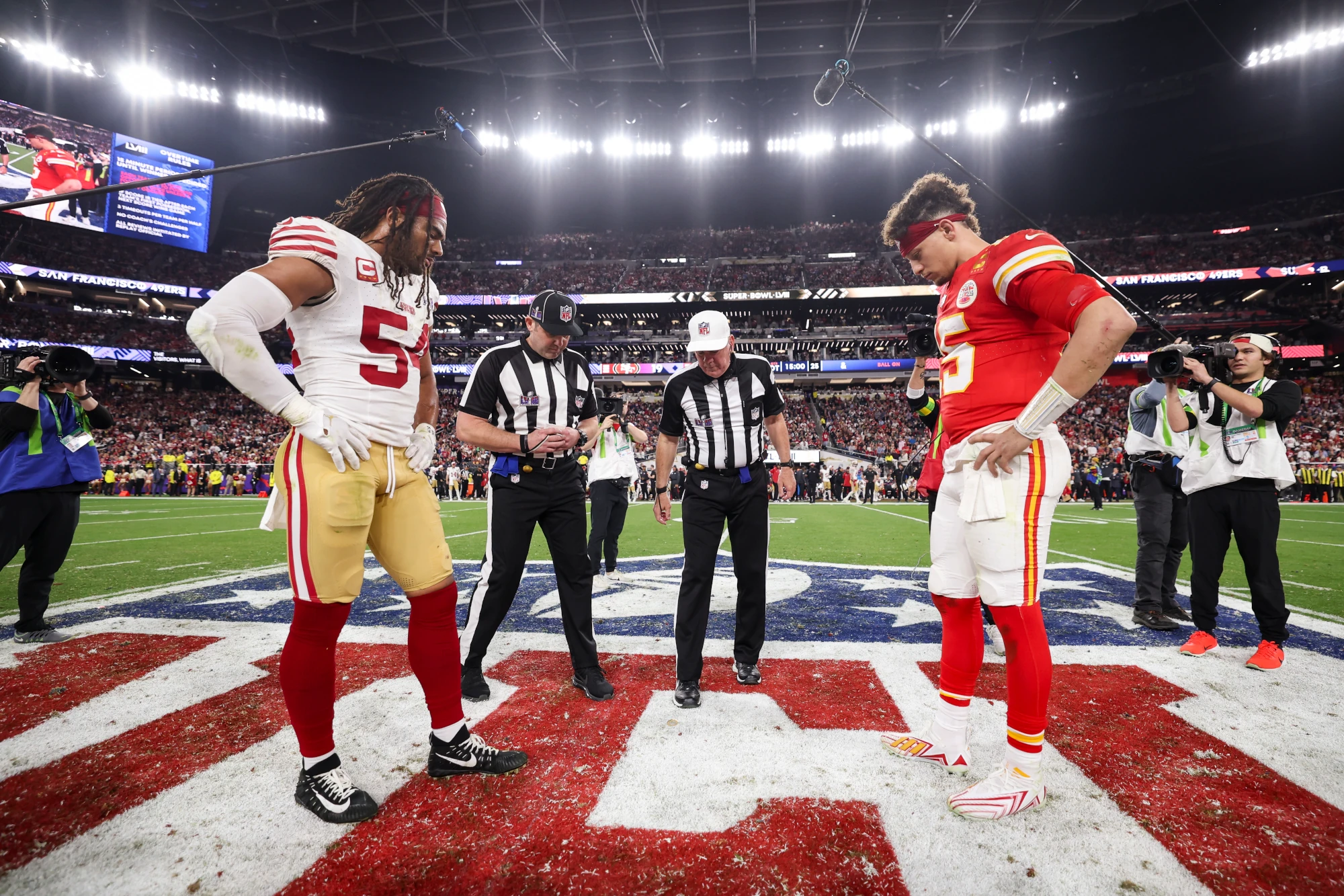 Fred Warner of the San Francisco 49ers and Patrick Mahomes of the Kansas City Chiefs look onto the coin toss before overtime of Super Bowl LVIII at Allegiant Stadium on February 11, 2024 in Las Vegas, NV. 