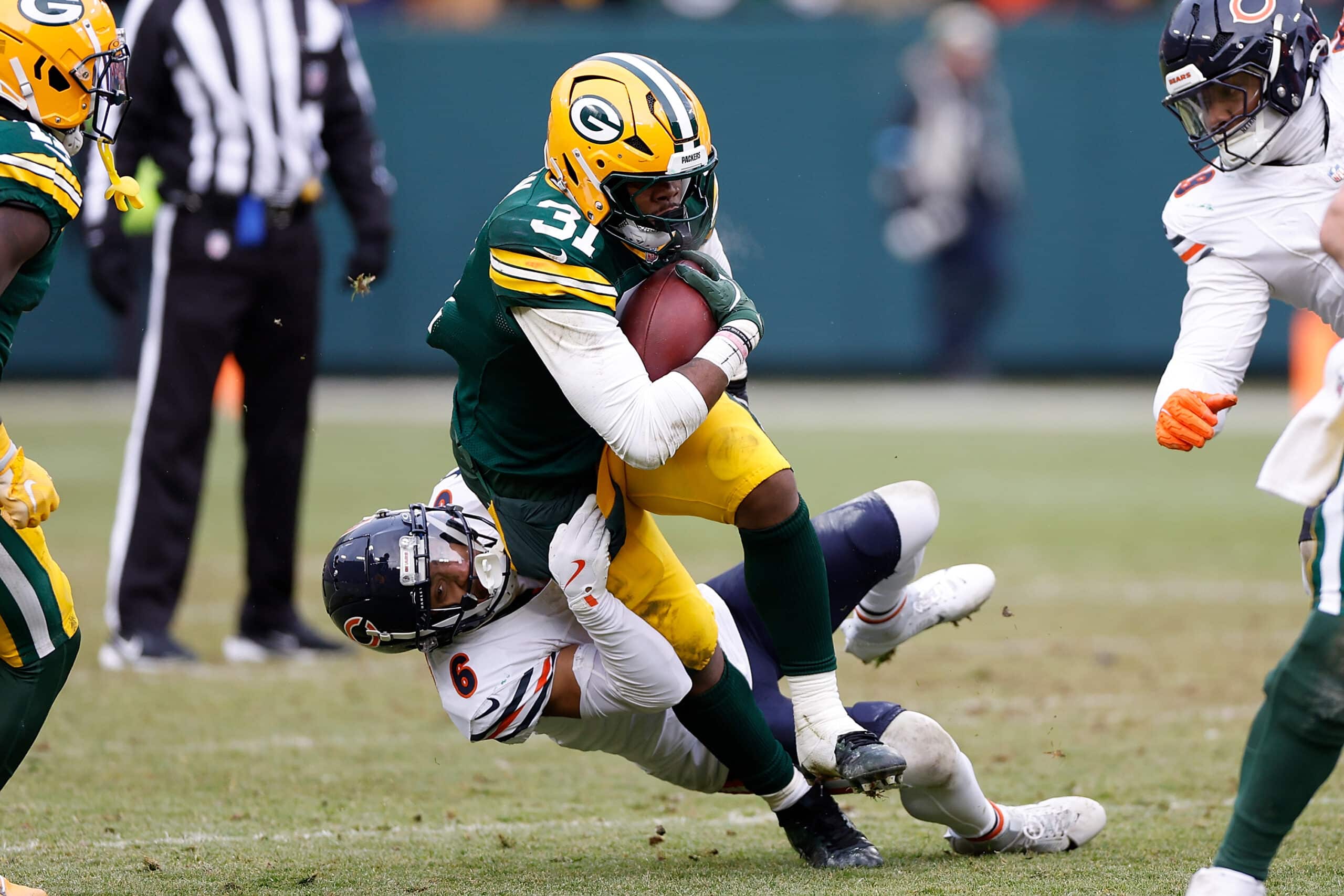  Emanuel Wilson #31 of the Green Bay Packers is tackled by Kyler Gordon #6 of the Chicago Bears at Lambeau Field on January 05, 2025 in Green Bay, Wisconsin.