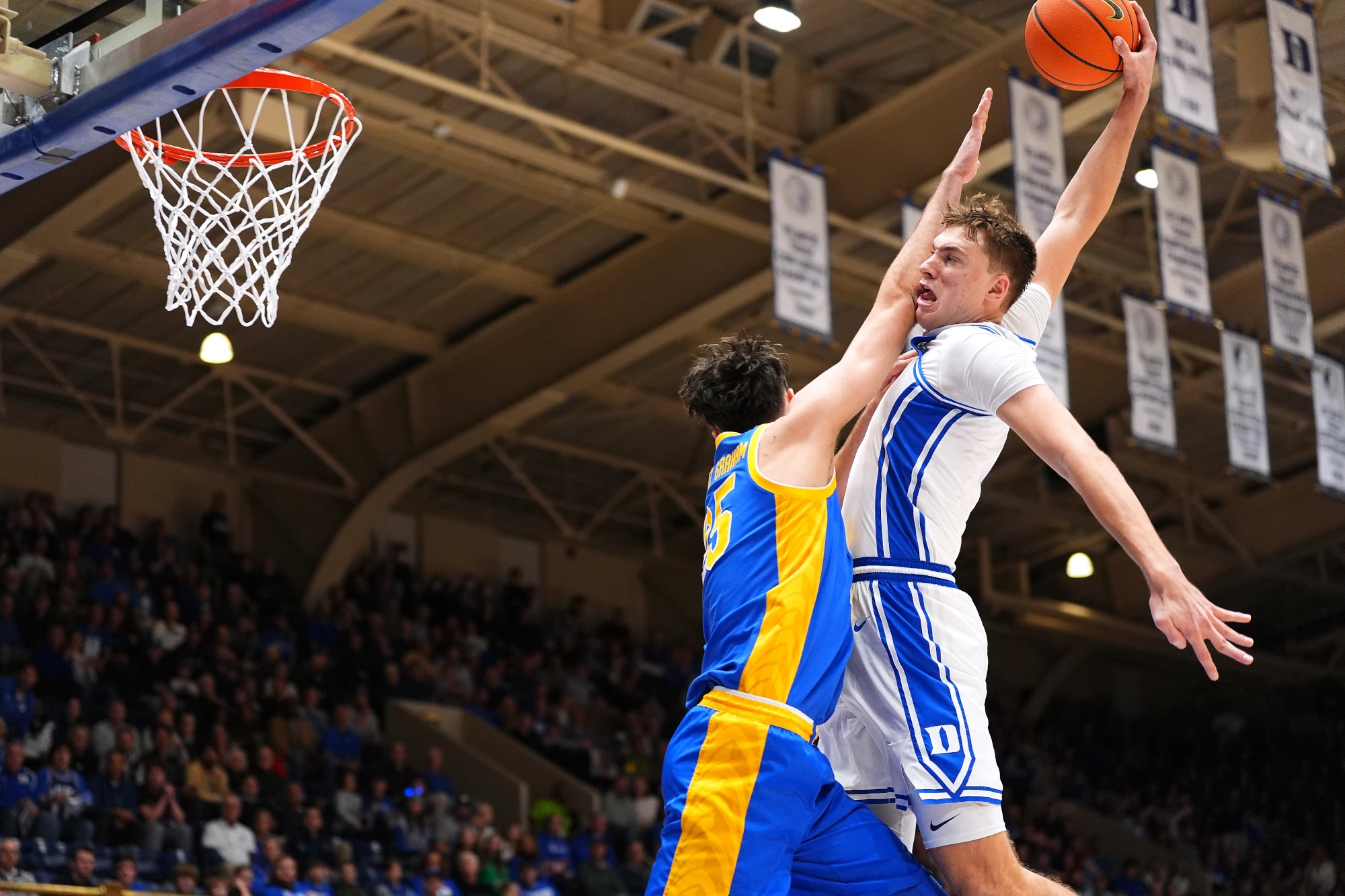 Cooper Flagg #2 of the Duke Blue Devils dunks over Guillermo Diaz Graham #25 of the Pittsburgh Panthers during the second half of the game at Cameron Indoor Stadium on January 07, 2025 in Durham, North Carolina. 