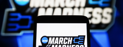 A March Madness (NCAA Division I men's basketball tournament) logo is seen on a smartphone and a PC screen.