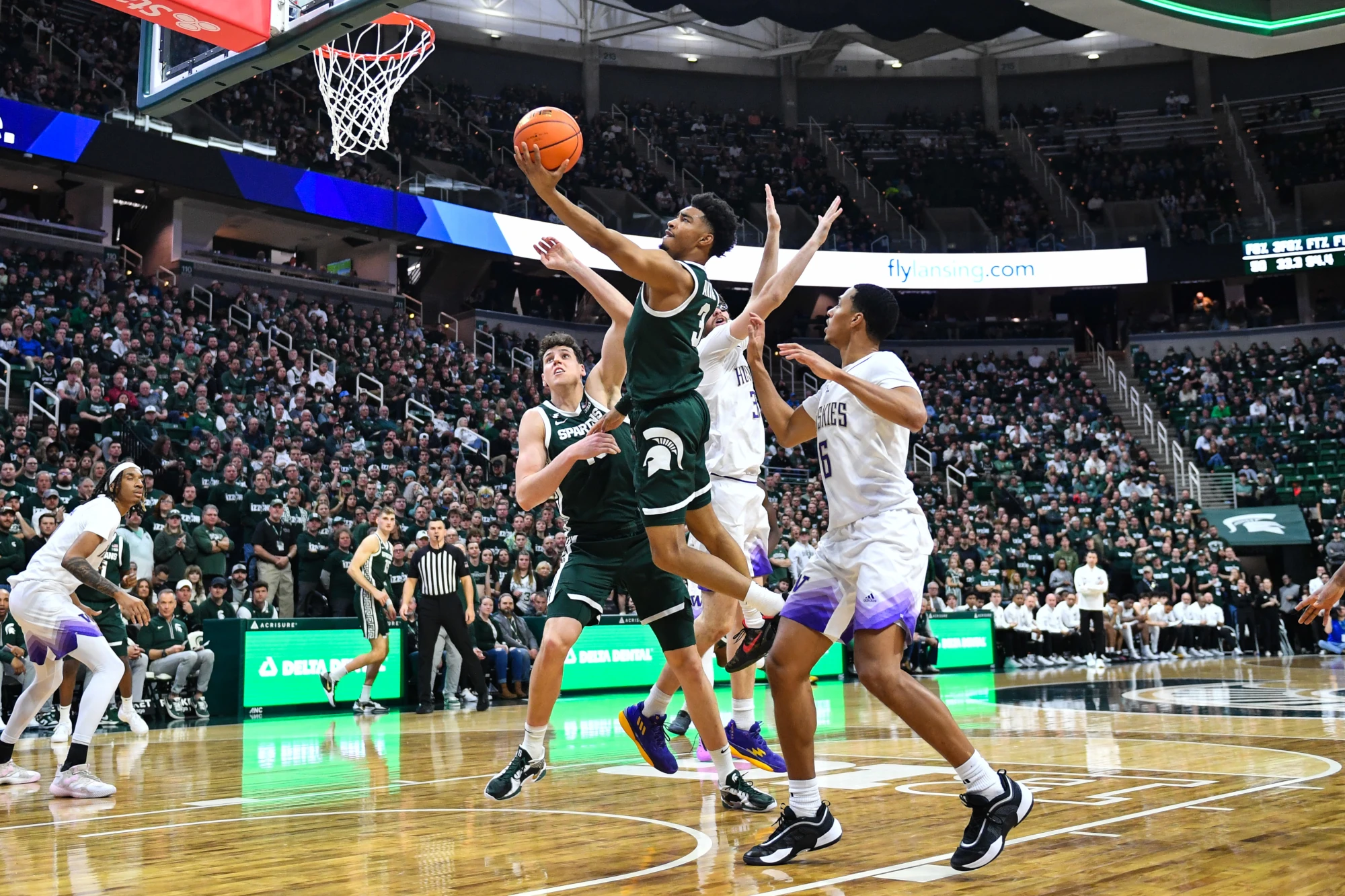 Michigan State Spartans guard Jaden Akins scores at the basket during a college basketball game between the Michigan State Spartans and Washington Huskies on January 9, 2025 at the Breslin Center in East Lansing, MI. 