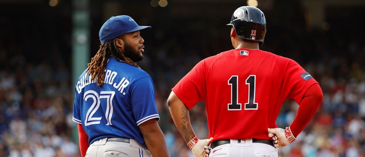 Vladimir Guerrero Jr. #27 of the Toronto Blue Jays talks with Rafael Devers #11 of the Boston Red Sox during the third inning at Fenway Park on August 5, 2023 in Boston, Massachusetts