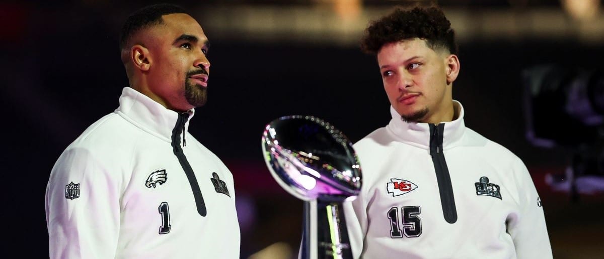 Jalen Hurts #1 of the Philadelphia Eagles and Patrick Mahomes #15 of the Kansas City Chiefs stand on stage next to the Vince Lombardi Trophy during Super Bowl LIX Opening Night at Caesars Superdome on February 3, 2025 in New Orleans, Louisiana.